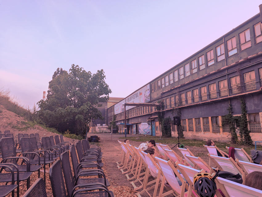 Folding chairs arranged outside a disused factory in Brno for an outdoor movie screening